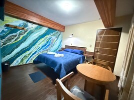 Una habitación con una cama, una mesa y una silla.