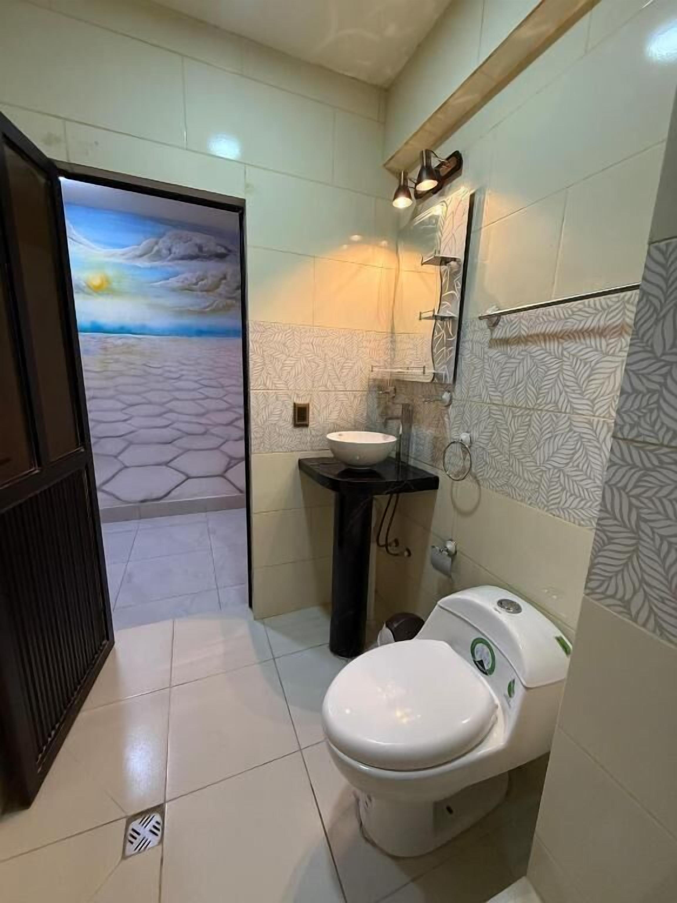 Un baño con inodoro, lavamanos y espejo.