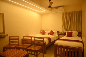 Habitación de hotel con dos camas, muebles de madera, ventilador de techo y aire acondicionado.