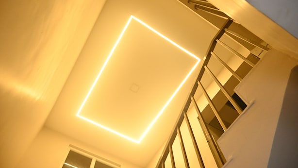 A staircase with a modern light fixture on the wall. - SANDALCITY HAVEN (Sathyamangalam)