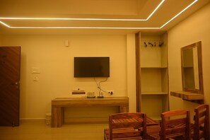 Una habitación con un banco de madera, un televisor montado en la pared y un espejo.