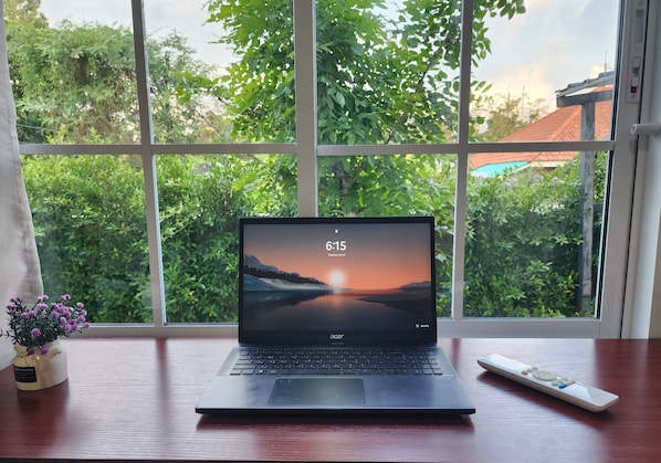 Ein Laptop auf einem Schreibtisch mit Blick aus dem Fenster.