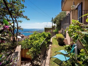 A garden with a view of the sea, a staircase, and a building with a balcony. - CORTE DELL'ULIVO| Sea View & Private Parking in Taormina Holiday Home (CAV) (Taormina)