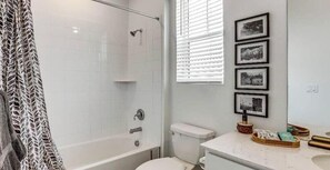 Une salle de bain avec douche, toilettes et lavabo.