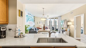 A modern kitchen with a built-in sink, a coffee maker, and a refrigerator. - Updated + clean family resort with Gulf & resort pool views. On-site restaurant (Destin)