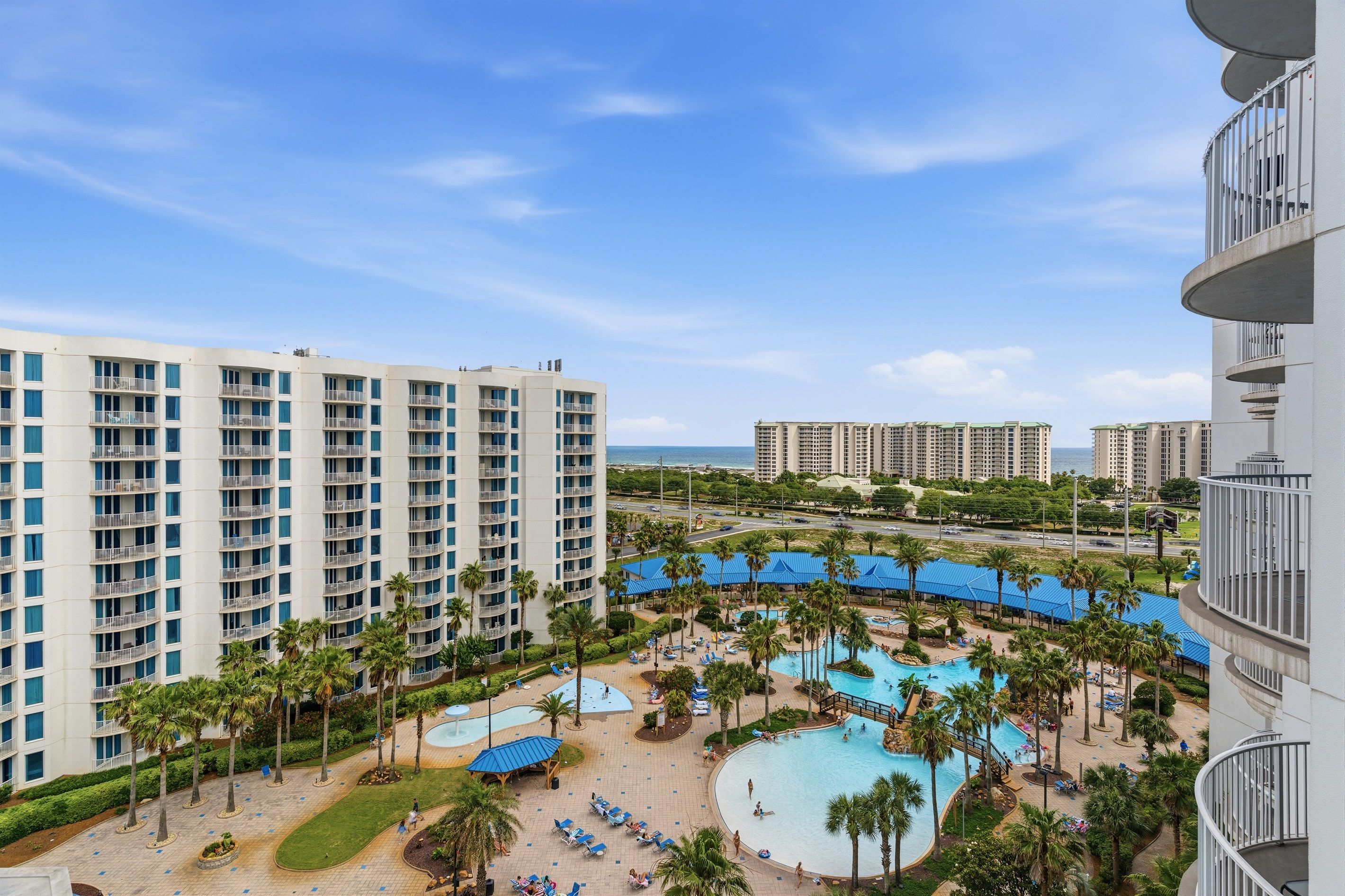 Um resort com vários edifícios, piscina e palmeiras.
