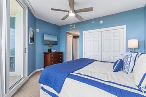 A bedroom with a bed, a ceiling fan, a door, and a view through a glass door. - Summer Ending 15% off – Gulf Views, Pool, Hot tub, Tennis, Pickle Ball ++ (Destin)