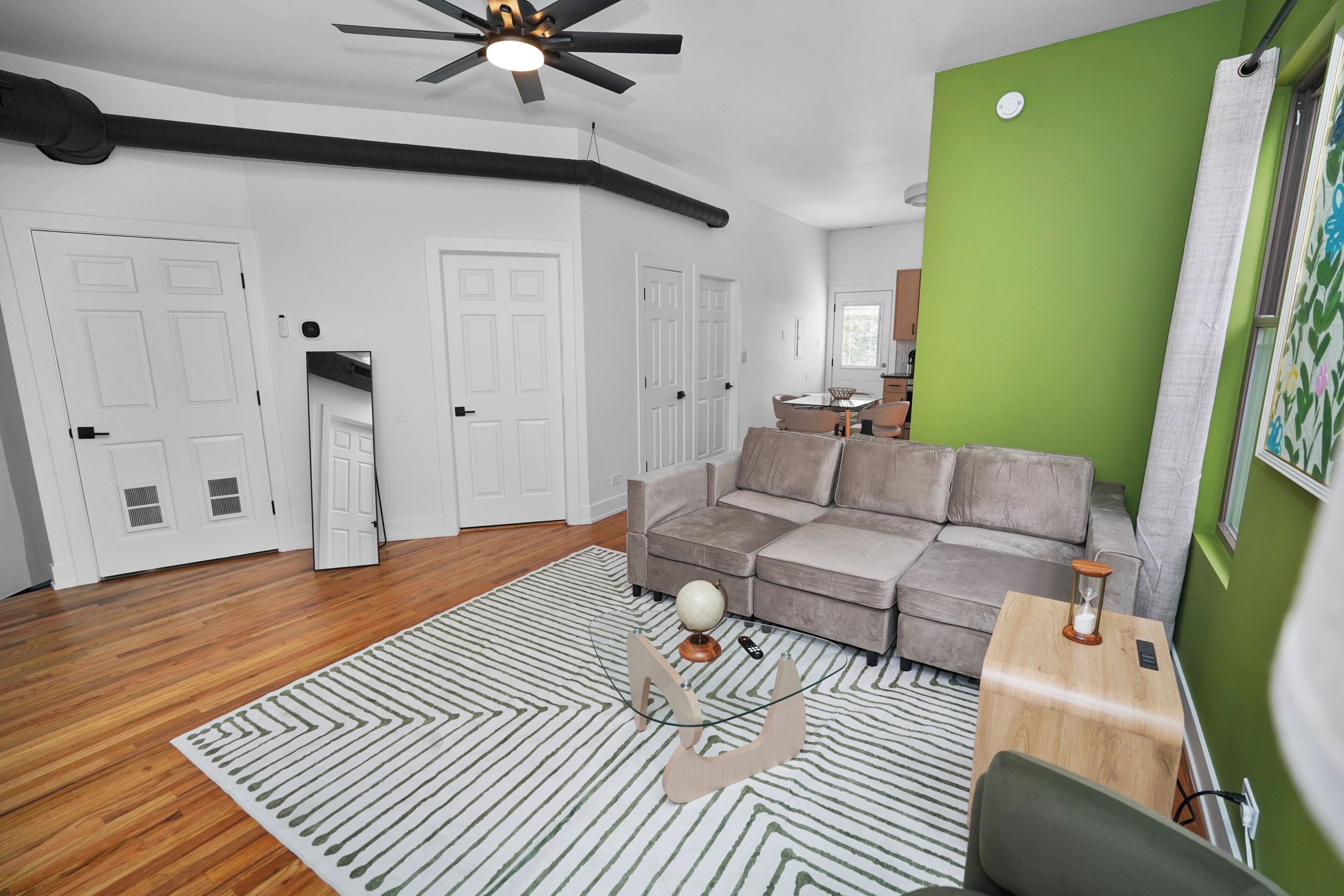 A living room with a sofa, a coffee table, and a ceiling fan.