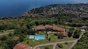 Eine Vogelperspektive auf ein Küstenanwesen mit Schwimmbad, einem großen Gebäude und einer umliegenden Landschaft.