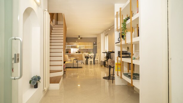 A modern interior with a staircase, a kitchen area, and a bookshelf. - Corte Cavour in the City Center (Gallarate)