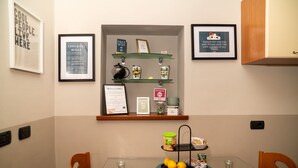 A hotel room with a glass table, chairs, a framed welcome sign, a checkout rules sign, a free wifi sign, and a cat warning sign. - Bianca in the Heart of the City (Somma Lombardo)