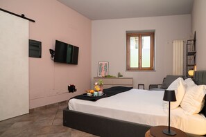 A bedroom with a bed, a TV, a window, a bedside table, and a lamp. - Da Gise: Garden, Wifi, Malpensa (Somma Lombardo)