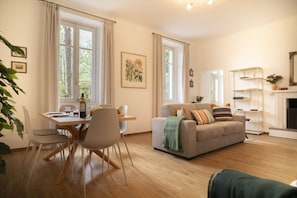 Ein Wohnzimmer mit einer Couch, einem Esstisch, Stühlen und einem Kamin.