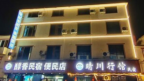 Un edificio de varios pisos con letreros iluminados para un hotel y un restaurante.