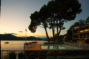 A swimming pool with a view of the water and mountains in the background. - Henriette Apt Terrace, Lake Access (Angera)