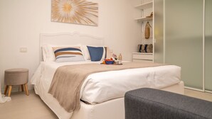 A modern bedroom with a bed, bedside table, and a chair. - LAKESCAPE apartment with terrace, view and pools (Gignese)