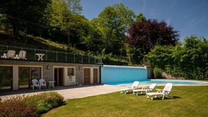 A modern building with a swimming pool, outdoor seating, and a grassy area. - LAKESCAPE apartment with terrace, view and pools (Gignese)
