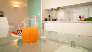 A kitchen with a glass pitcher of orange juice on a marble countertop. - LAKESCAPE apartment with terrace, view and pools (Gignese)