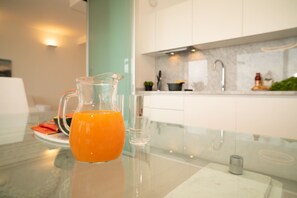 Eine Küche mit einem Glasgefäß Orangensaft auf einer Marmorarbeitsplatte.