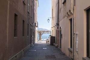 A narrow alleyway between buildings with a clear view of a lake and mountains in the distance. - Blue Horizon - pools, terrace and lakes view (Lesa)