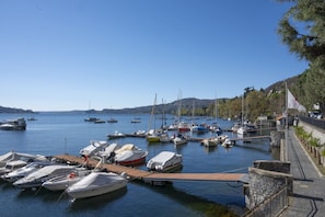 A marina with boats docked, a wooden dock, and a stone wall. - Blue Horizon - pools, terrace and lakes view (Lesa)