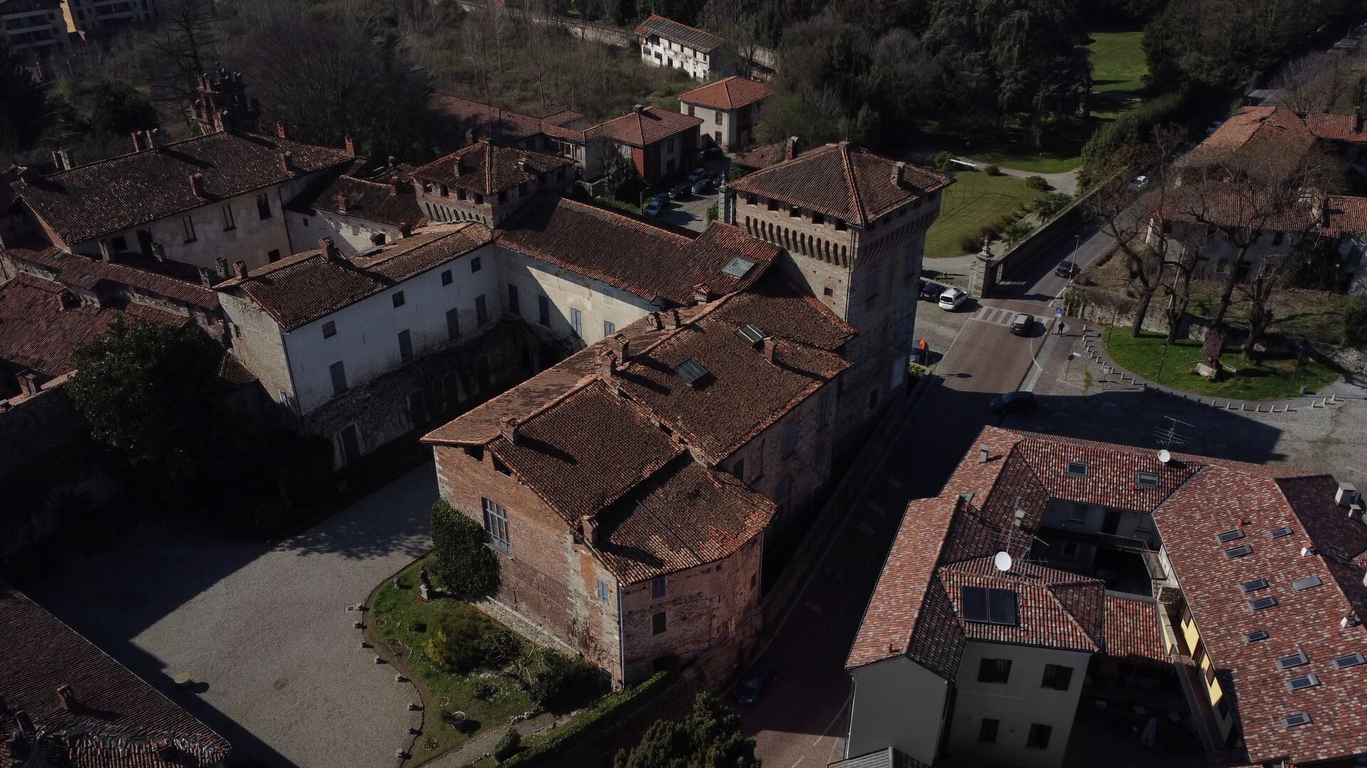 Una vista aerea di una città storica con architettura medievale, tra cui una torre imponente e una piazza centrale.