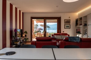 Ein Wohnzimmer mit einem roten Sofa, einem Fernseher und einem Tisch mit einem Schläger.