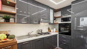 A modern kitchen with grey cabinets, stainless steel appliances, and a wooden countertop. - Mazzini 1 - Smart Flat 2 bedrooms Garage (Gallarate)
