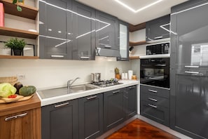 A modern kitchen with grey cabinets, stainless steel appliances, and a wooden countertop. - Mazzini 1 - Smart Flat 2 bedrooms Garage (Gallarate)