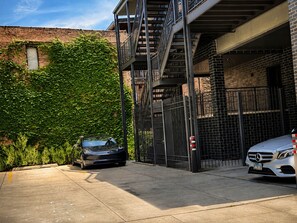 A parking garage with a car and a Mercedes-Benz. - Spacious 4BR West Loop Retreat w/Optional Parking (Chicago)