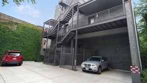 Een parkeergarage met meerdere verdiepingen, met een trap, een rode auto en een zilveren auto erin.