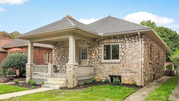 A stone house with a covered porch, a small front yard, and a neighboring brick house. - Stone's Throw Bungalow - Cozy and Convenient in Chambersburg, PA (Chambersburg)