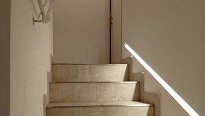 A staircase with beige tiles, a handrail, and a door at the top. - Il Sassolino - Hostel (Riomaggiore)