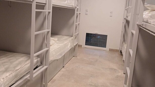 A bunk room with bunk beds, a tiled floor, and an air conditioning unit on the wall. - Il Sassolino - Hostel (Riomaggiore)