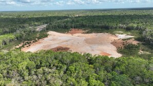 An aerial view of a natural landscape with a clearing surrounded by dense vegetation. - Camping and RVs Selva Maya (Reforma Agraria)