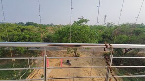 A construction site with a metal fence, a tree, and a scooter. - Sandhya Guest House (Ekangardih)