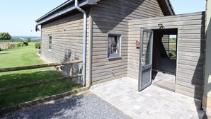 A wooden building with a sloped roof, a door, and a small window.