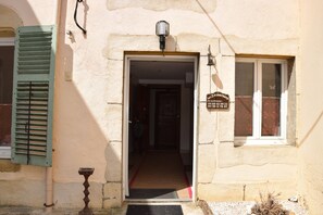 A building entrance with a door, a window, and a sign.