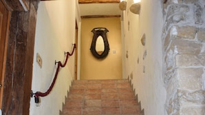 Un escalier avec des murs en pierre et une porte en bois.