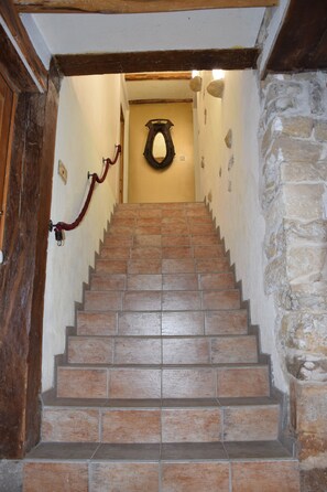 A staircase with stone walls and a wooden door.