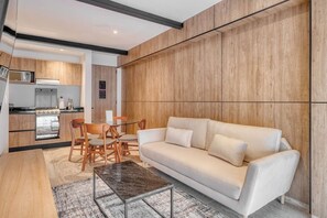 Ein modernes Wohnzimmer mit Sofa, Couchtisch und Essbereich.