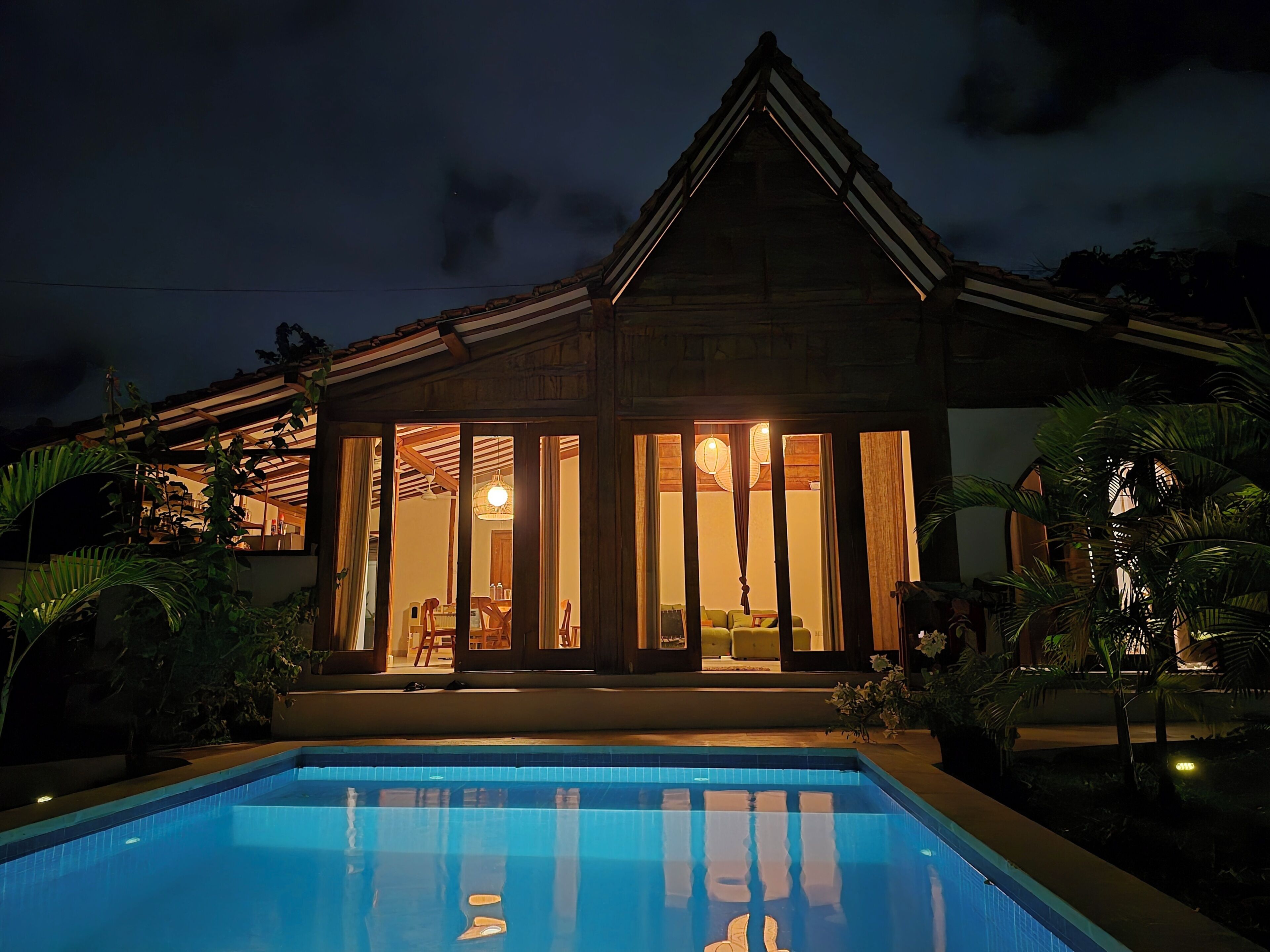 Ein Haus mit Swimmingpool, Holzfassade und großen Fenstern.