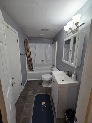 Une petite salle de bain comprenant une baignoire, des toilettes et un lavabo.