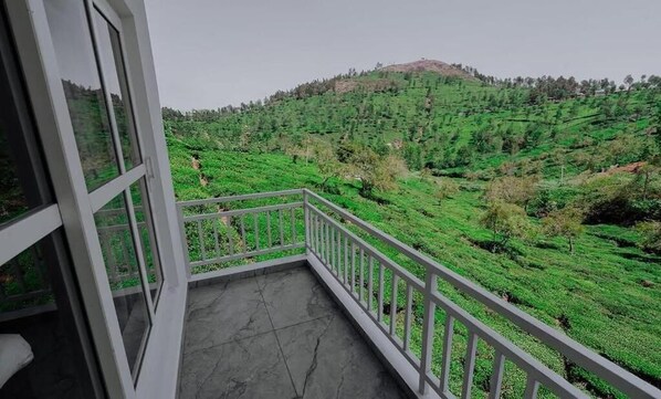 A balcony with a view of terraced tea fields.