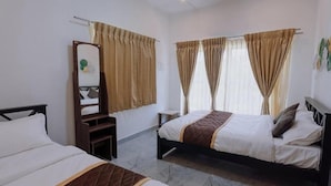 Habitación de hotel con dos camas, un espejo, una mesita y cortinas.