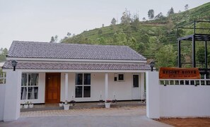 A white building with a tiled roof, a wooden door, and a sign that reads 'Resort Rover Lensi.'