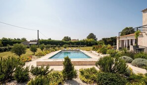 A rectangular swimming pool surrounded by landscaped garden beds and various shrubs. - Couples getaway with pool and pool house (Arles)