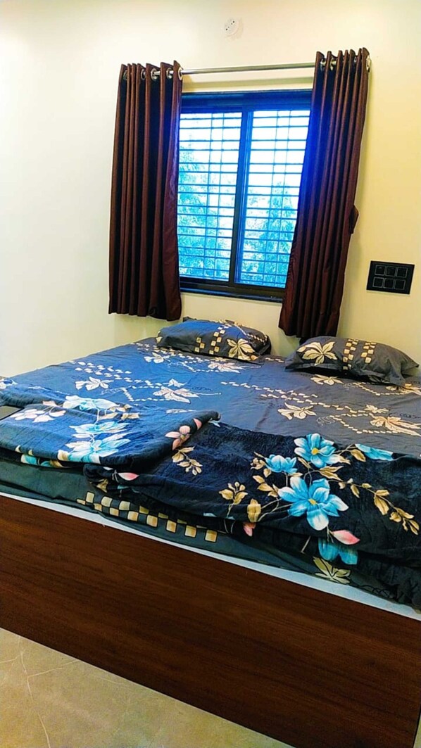 A bedroom with a bed, curtains, a window, and a wall switch. - Hotel Palvi (Rahata)