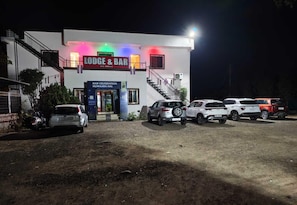 A building with a sign reading 'LODGEE & BAR' and another sign for 'HAR CELEBRATION HUMARA HAI'. - Hotel Palvi (Rahata)