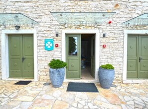 A stone building with green doors, a sign reading 'JURACA,' and two large planters. - Tranquil Getaway With Shared Pool in Bale - One Bedroom Apartment (Bale)